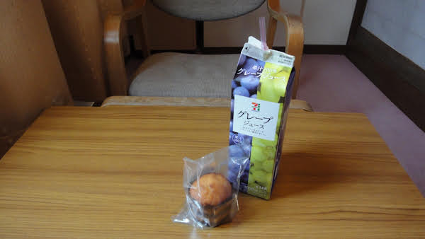 a small muffin and a carton of grape juice